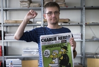 Vydavatel francouzského satirického týdeníku Charlie Hebdo, známý jen jako Charb, ukazuje číslo časopisu na kterém je karikatura Mohameda.