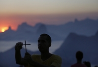 Muž v Brazílii znázorňuje dvěma tužkama křiž. Uctívá tak památku redakce Charlie Hebdo. 