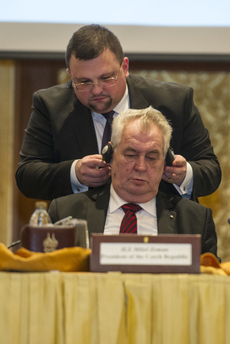 Hradní protokolář Jindřich Forejt nasazuje prezidentovi sluchátka.