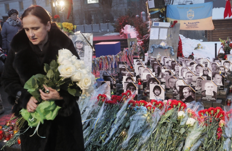 Lidé na počest padlých při převratu zapalují svíčky na náměstí Nezávislosti v Kyjevě.