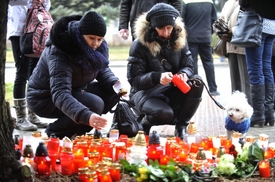 Lidé se shromažďují a zapalují svíčky, aby uctili památku obětí střelby.