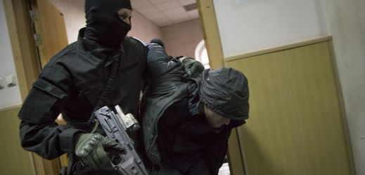 Jeden ze zadržených v doprovodu policisty na chodbě soudu v Moskvě.
