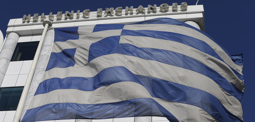 Řecká vlajka před budovou akciové burzy v Aténách.
