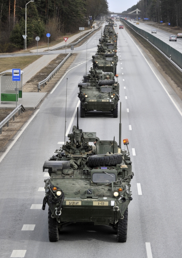 Představitelé americké armády putují v obrněných vozidlech Stryker.