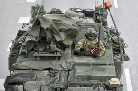 Americký voják v transportéru Stryker během cesty konvoje Lotyšskem.