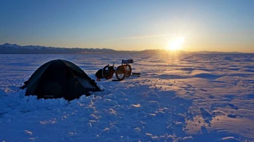 Cestovatel stanoval přímo na ledě. Romantický pohled na západ slunce byl zaslouženou odměnou za celodenní dřinu s tříkolkou.