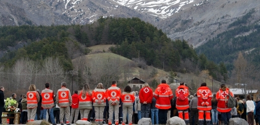 Pracovníci Červeného kříže drží pietu za oběti havárie.