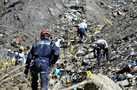 Záchranáři zkoumají místo nehody letadla.