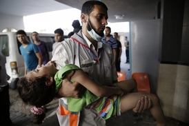 Palestinský lékař nese na rukou dívku zraněnou při útocích v pásmu Gazy.