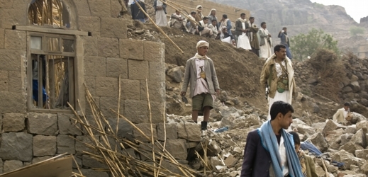 Jemenci v troskách vesnice, která byla zničena bombardováním arabské koalice.