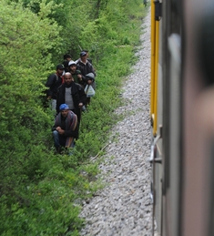 Migranti z Afriky podél vlakové trati.