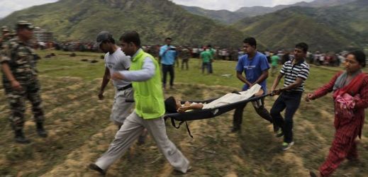 Nepálci nesou zraněnou oběť do vrtulníku.