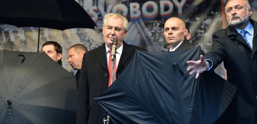 Zemana loni na pražském Albertově museli bodyguardi chránit deštníky.