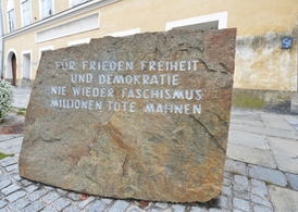 Pamětní deska před domem připomínající miliony obětí nacismu.