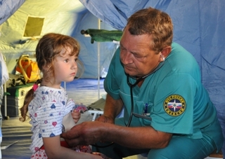 Ruský lékař prohlíží malou uprchlici z Ukrajiny.