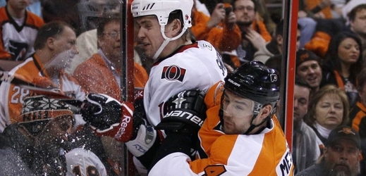 Andrej Mezsároš (v oranžovém) v souboji se Zackem Smithem v dresech týmů NHL.