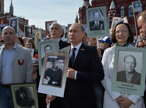 Ruský prezident Vladimir Putin nesoucí podobiznu svého otce.