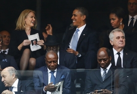 Thorning-Schmidtová s Barackem Obamou na tryzně za Nelsona Mandelu. Vpravo Michelle Obamová.
