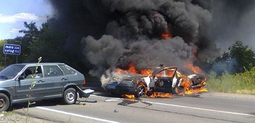 Hořící policejní auto během víkendových přestřelek v Mukačevu.
