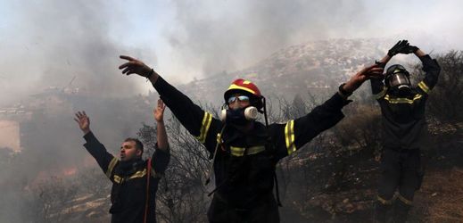 Řečtí hasiči dávají pokyny vrtulníku. Hora Ymittos v Aténách.
