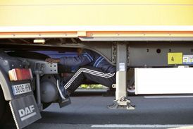 Migrant se ukrývá na podvozku kamionu, který směřuje do Velké Británie.