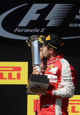 Sebastian Vettel se mazlí s trofejí za vítězství v Maďarsku.