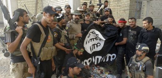 Irácké bezpečnostní síly podporované provládními bojovníky slaví, protože drží vlajku islámského státu, kterou při střetech s radikály vzali (ilustrační foto).