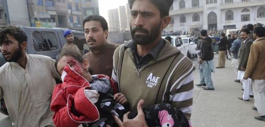 Muž nese malou dívku, která byla zraněna při útoku na školu v Pešávaru.