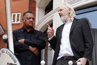 Julian Assange (vpravo) na balkoně.