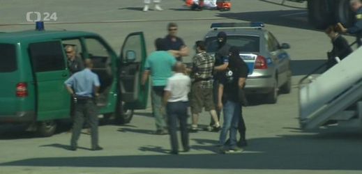 V Praze přistálo letadlo s Kevinem Dahlgrenem (na snímku uprostřed v kostkované košili), který byl obviněn ze čtyřnásobné vraždy v Brně-Ivanovicích z roku 2013.