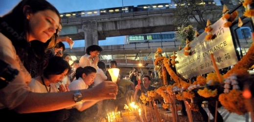 Lidé v Bangkoku zapalují svíčky za oběti bombového útoku na chám. 