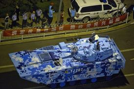 Čínská policejní hlídka hlídá průjezd tanku při příležitosti oslav konce druhé světové války na tanku. Běžní občané se do blízkosti vozů nedostanou.