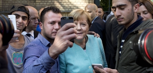 Angela Merkelová se fotografuje s migranty.