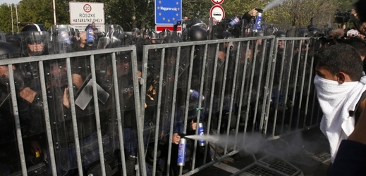 Maďarská policie se snaží udržet uprchlíky za plotem.