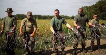 Maďarští vojáci rozmisťují NATO drát.