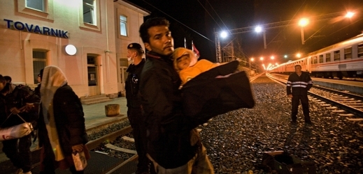 Rodina uprchlíků překračuje maďarskou hranici.