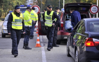 Kontroly všech do Čech projíždějících aut provádí policisté na 14 z 20 přechodů. Na snímku policisté a celníci v Nové Bystřici na Jindřichohradecku.