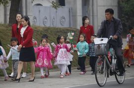 Korejské děti nesoucí dekorativní květiny na oslavu výročí.