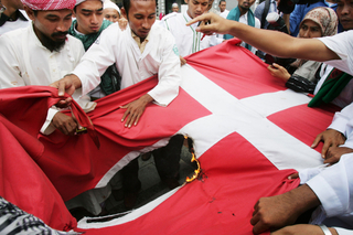 Po zveřejnění dánských karikatur Mohammeda trhají a pálí dánské vlajky v Jakartě.