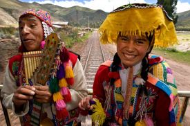 Hudebníci a tanečníci v tradičních kostýmech doprovázejí turisty mířící na Machu Picchu v Andském vlaku Orient Express.