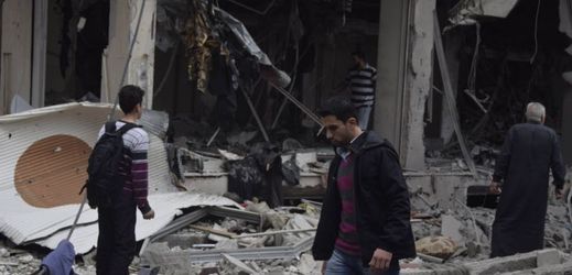 Na snímku lidé shromažďující se v blízkosti budov zničených náletem. Duma, Sýrie.