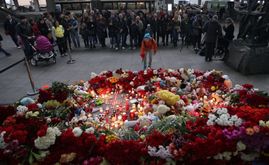 Lidé nosí na letiště k uctění památky obětí svíčky, kytice i plyšáky.