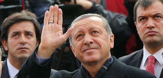 Prezident Erdogan mává svým příznivcům, poté co odhlasoval v jedné z volebních místností v Istanbulu.