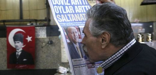 I když tisk Erdogana nemá rád, Turci ho chtějí. Na snímku muž líbající prezidentovu fotografii v novinách.