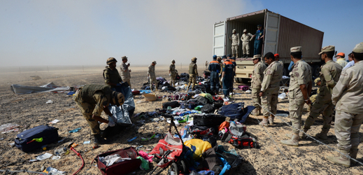 Egyptští vojáci sbírají věci pasažérů v okolí místa nehody.