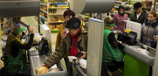 Lidé směňují poukázky za jídlo v supermarketu na východě Ukrajiny.