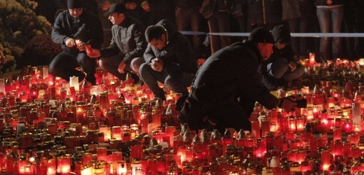 Lidé zapalují svíčky za oběti v Bukurešti.