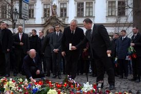 Prezident za pomoci šéfa protokolu Pražského hradu Jindřicha Forejta pokládá na zem svíčku.