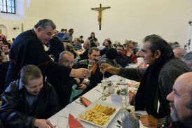 Tradiční vánoční oběd pro bezdomovce, seniory a postižené v arcibiskupském paláci na Pražském hradě. Kardinál Dominik Duka (vlevo).