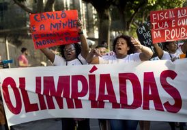 Lidé protestují proti letním olympijským hrám v Riu de Janeiru. Na plakátech stojí: Jsem pouliční prodavač a moje rodina hladoví.